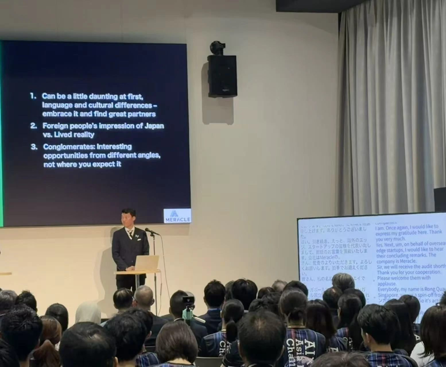 STATION Aiで、日英のリアルタイム字幕画面の横で発表するAI×MedTechの登壇者。