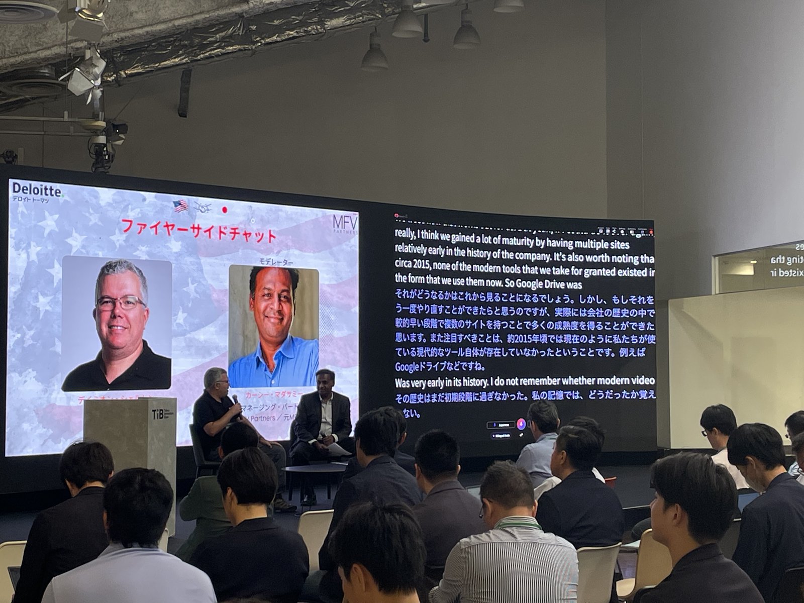 Tokyo Innovation Base のファイアサイドチャット。パネルの隣のスクリーンに VoicePing のリアルタイム翻訳が表示されている。