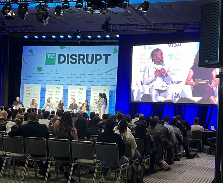 TechCrunch DisruptのFintechステージで、登壇者が椅子に座って議論している様子