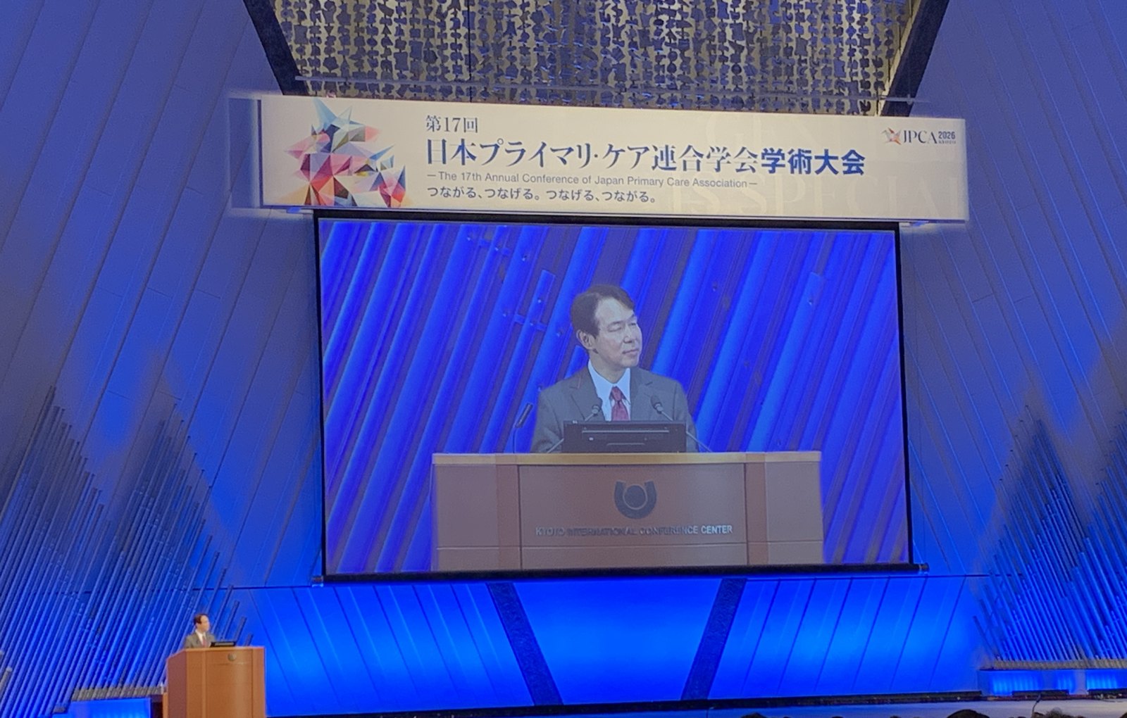 JPCA 2026 のメインスクリーンに映る登壇者（国立京都国際会館）。