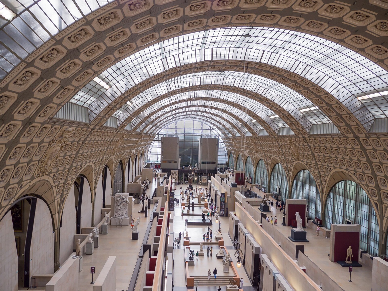 旧駅舎のガラス天井の下に彫刻が並ぶオルセー美術館の中央ホール