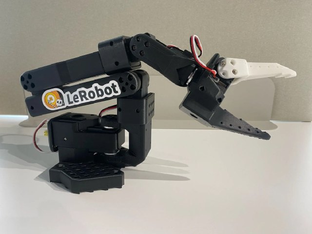 黒い3Dプリント製リンク、露出した配線、平行グリッパーを備えたSO-101フォロワーアーム。