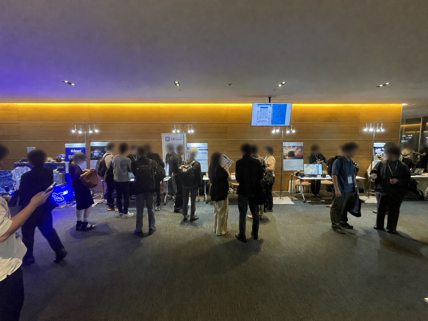 Sony Open Innovation Day 2026の展示ブースを見学する、顔にぼかし処理を施した参加者。